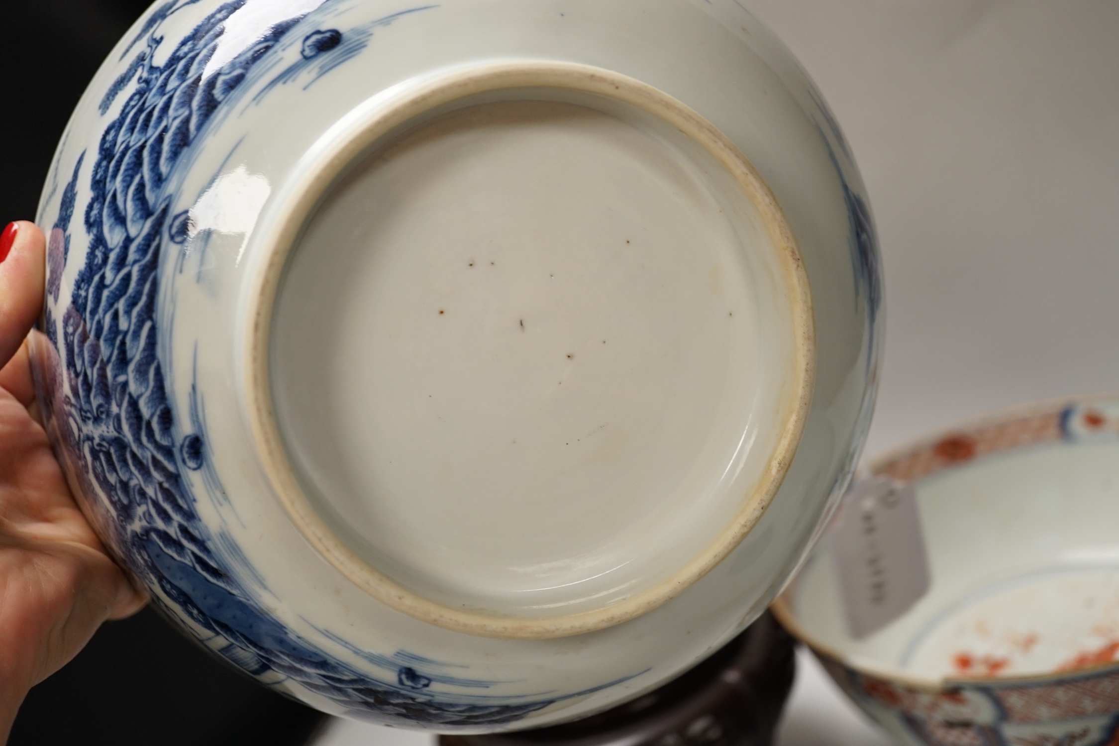 Four 18th century Chinese porcelain bowls (a.f), one with hardwood stand, largest 28cm diameter